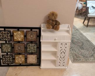 Metal decorative wall hanging and white wall shelf