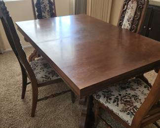  vintage carved wood dining table and chairs set, likely 1960s–70s Mediterranean Revival style. It includes:
Solid wood rectangular dining table with ornate pedestal-style carved base.   
Matching carved dining chairs with 
floral tapestry upholstery (4 chairs total