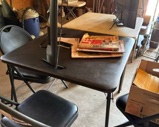 Several card tables with chairs and flat screen tvs and vintage magazines some from WWII