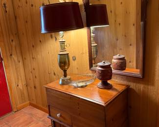 Blanket chest with brass lamp and metal shade and decor mirror