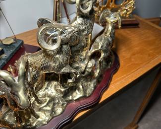 vintage brass sculpture on a wooden base