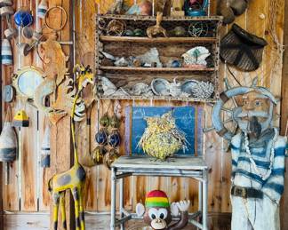 Hand carved life sized sea boat captain, metal folk art giraffe art, metal folk art monkey, seashells, brass porthole window,  colored glass fishing floats, wicker fishing creel, cast iron mermaid