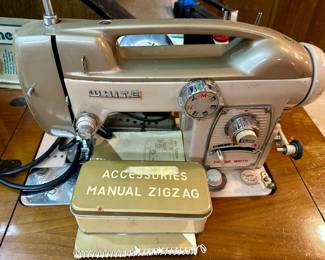 Very old White sewing machine in cabinet.