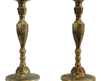 This superb pair of antique brass candlesticks is a rare and beautiful example of cross-cultural design, seamlessly blending intricate Islamic geometric patterns with more traditional European forms. The tall, elegant baluster shape is a classic European design, while the meticulous, hand-engraved patterns that cover every surface are reminiscent of the fine metalwork of the Middle East and North Africa. The attention to detail is remarkable, showcasing a high level of craftsmanship. As a matching pair, these candlesticks are ideal for adding a touch of exotic elegance and antique charm to a dining table or mantelpiece.