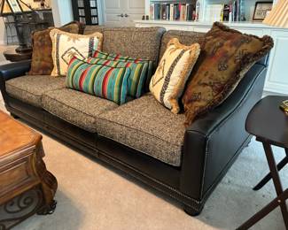 Leather sofa with nail head trim and upholstered cushions