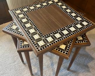 Set of mid-century modern stacking tables with wood and tile tops.