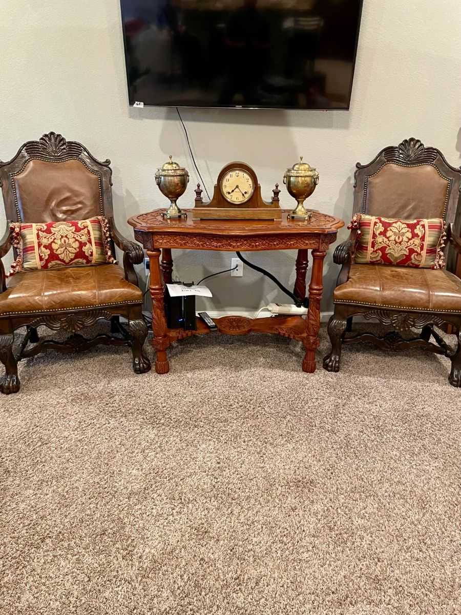 Vintage Leather Chairs and intricately carved table with brass urns. Clock has sold