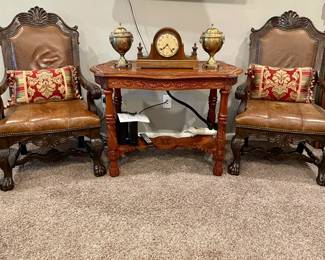 Vintage Leather Chairs and intricately carved table with brass urns.  Clock has sold