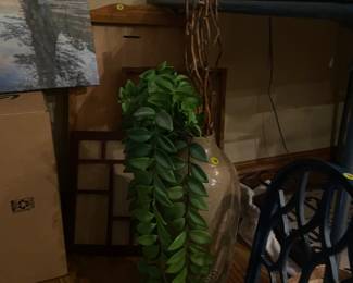 Tall, beige vase with lighted twigs & greenry.