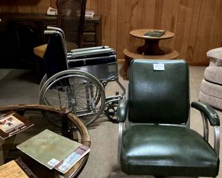 Leather padded swivel rolling desk chair with arms fits under custom built desk and bookcases in corner of Den.