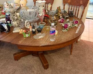 Large oval oak dining table with numerous collectibles - lots of great items on the table!