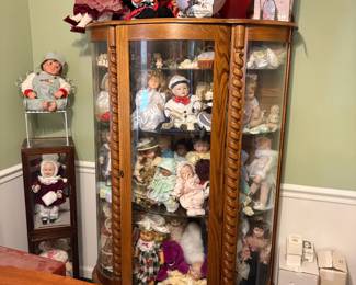 . . . oak curved-glass china cabinet and collectible dolls