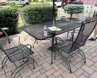 . . . wrought-iron table and chairs with umbrella  