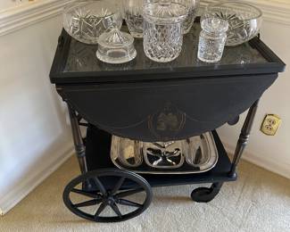 Vintage black and gold serving cart with removable tray, Block, Waterford, and other lead crystal pieces.