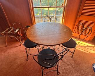 Antique round table with metal base and four medal ice cream parlor chairs