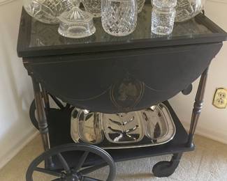 Vintage black and gold serving cart with removable tray, Block, Waterford, and other lead crystal pieces.