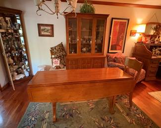 This is a wonderful table. It is narrow enough to go anywhere but with the sides folded out, it will seat an easy 6 to 8 people. It comes with 4 nice matching chairs. The hutch in the background is a good match for it and is in great condition.