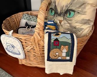 Ooh...this kitty looks mad. A basket of kitty towels and kitchen items.