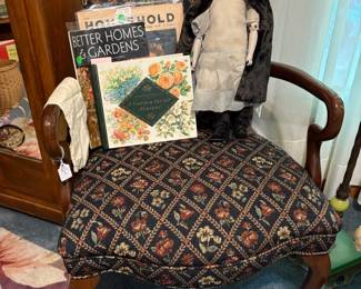 Another nice antique chair holding a bisque doll and various paper ephemera.