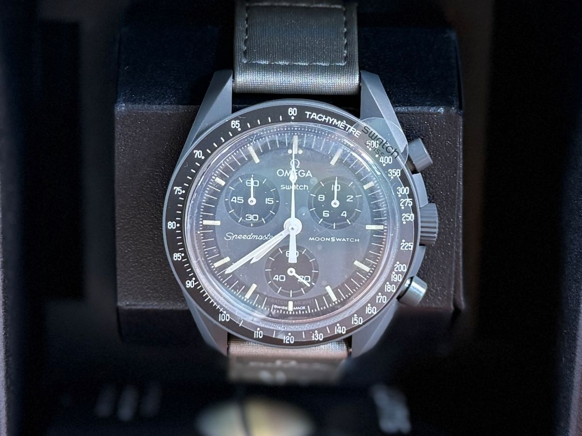 This lot features an Omega Mission to Mercury Swatch, new in the box and in complete condition. oWith its intense deep gray color and metallic gray VELCRO® strap, this non-limited watch means business. The chronograph seconds hand, subdial hands and tachymeter scale are in white. The subdials and bezel are in black. All dials in the collection carry the OMEGA X Swatch branding, the iconic Speedmaster logo and the MoonSwatch logo. The biosourced glass construction, the etched “S” integrated in the center of the glass, the fine and sophisticated circular pattern on the dial outer ring and the recessed subdials, the angular and smooth lugs construction, the iconic “dot over 90” detail on the tachymeter scale, and of course the unique Bioceramic feel are common to all models. The hour, minute, and chronograph seconds hands as well as the hour markers sport Super-LumiNova® for a perfect glow in the dark.
