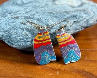 This lot features a pair of enamel earrings by Laurel Burch circa 1980s titled, “Rainbow Cats”. 
