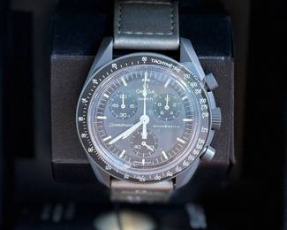 This lot features an Omega Mission to Mercury Swatch, new in the box and in complete condition. oWith its intense deep gray color and metallic gray VELCRO® strap, this non-limited watch means business. The chronograph seconds hand, subdial hands and tachymeter scale are in white. The subdials and bezel are in black. All dials in the collection carry the OMEGA X Swatch branding, the iconic Speedmaster logo and the MoonSwatch logo. The biosourced glass construction, the etched “S” integrated in the center of the glass, the fine and sophisticated circular pattern on the dial outer ring and the recessed subdials, the angular and smooth lugs construction, the iconic “dot over 90” detail on the tachymeter scale, and of course the unique Bioceramic feel are common to all models. The hour, minute, and chronograph seconds hands as well as the hour markers sport Super-LumiNova® for a perfect glow in the dark.
