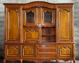 This lot features a large vintage wood hutch that can be transported in five different pieces. Includes three skeleton keys which function with every cabinet and drawer lock. Wired for lighting, but will need a new plug. Features adjustable shelving and measures, 81” H x 89” W x 20.5” D.
