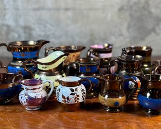 This lot features thirteen (13) pieces of copper lusterware in good overall condition. Copper lusterware is a type of pottery overglazed with metallic oxides, typically copper, and fired at a lower temperature to create an iridescent, metallic finish. This style of pottery was popularized in England during the 19th century, with modern lusterware appearing in England and Wales in the 1820s. 