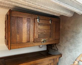Antique oak icebox with paneled sides, brass hardware, and a single front door. Compact size makes it a versatile decorative or storage piece.