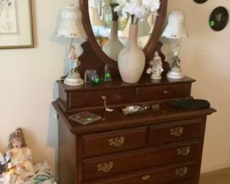 Mahogany dresser with round mirror.