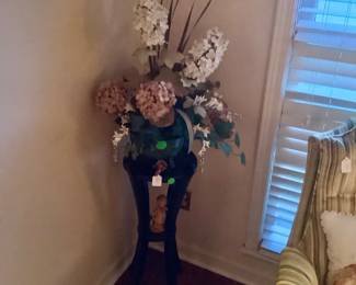 Hand made black table holding beautiful floral arrangement.