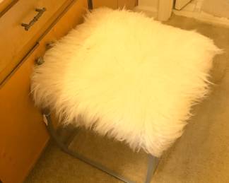 Metal stand with white fur.  Not only pretty, but very comfortable.