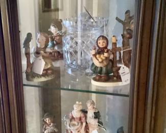 Just a few of the Hummel and porcelain , Waterford items in lighted curio cabinet.
