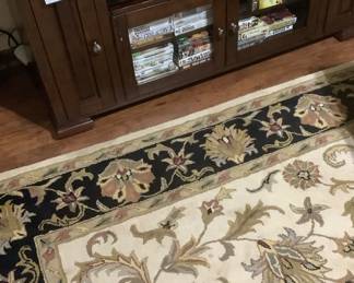 The area rug in the den. Beautiful colors with black trim.