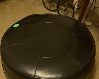 Black leather round ottoman.