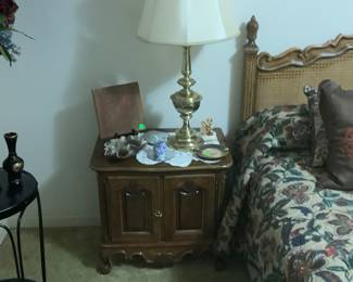 A view of one of the 2 matching end tables and headboard .