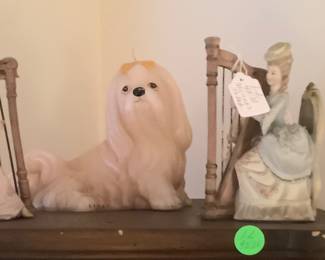 Musical porcelain figurine on top of curio cabinet with sweet candle dog.