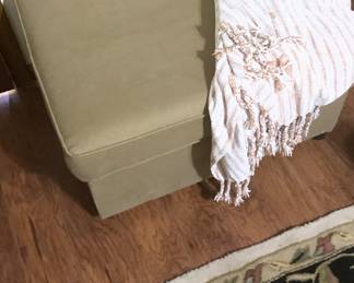The beige ottoman with wheels and storage.