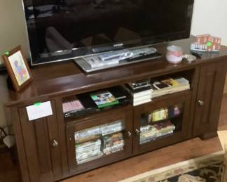 The entertainment center with a lot of C.D’s, records, and movies.