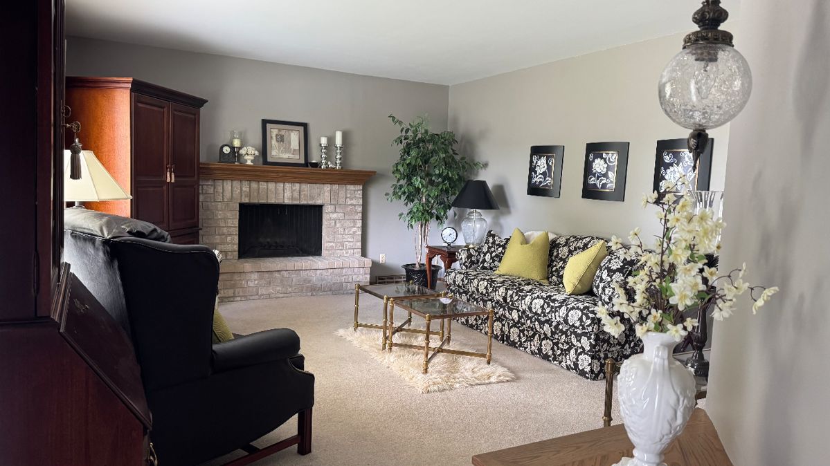Floral couch, striped chair, and leather recliner. Set of two glass end tables and matching console table. Armoire and glass display cabinet with pull-down desk.