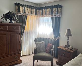 Oak armoire and nightstand. Dresser with mirror. Green armchair. 