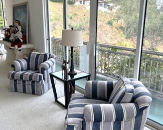 Another part of the house has these two matching chairs, as well as the glass-topped table, wooden figurines, and table lamp.