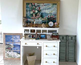 If the other desks were a tad too much, consider this much smaller version. Not only do you get the four drawers, but five small cubby-holes. Or take a look at the small mantle clock and the painting of summer fruit.