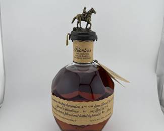 "Blanton’s Original Single Barrel is among the most sought-after bourbons in the world, celebrated as the first commercially released single barrel bourbon. Hand-selected from the legendary Warehouse H at Buffalo Trace Distillery, each barrel is carefully chosen for its exceptional character, making every bottle a one-of-a-kind expression of Kentucky craftsmanship. Encased in its signature horseshoe-shaped bottle topped with a collectible horse-and-jockey stopper, this release embodies both history and artistry. Every stopper is part of a series that spells out B-L-A-N-T-O-N-S, making it especially prized among collectors. This bottle stopper is "B".