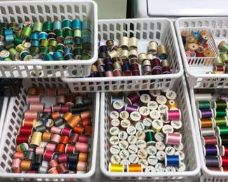 Spools of thread.  Sewing thread, embroidery thread.  Madeira, two bins on bottom right.  Vintage wooden spools top right.  