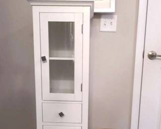 White Storage Cabinet With Art And Pottery Decor