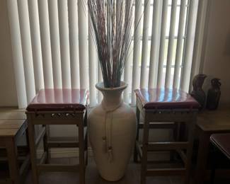 2 barstools that match the end tables and a large Southwestern vase