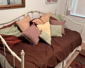 day bed with trundle and a massive amount of pillows, rug as well