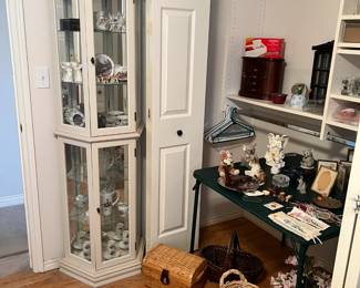 this angle of bedroom shows the same table but also captures the curio cabinet