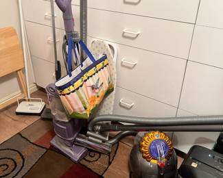 vacuums 3 styles seen here along with a ironing board, rug is also for sale.